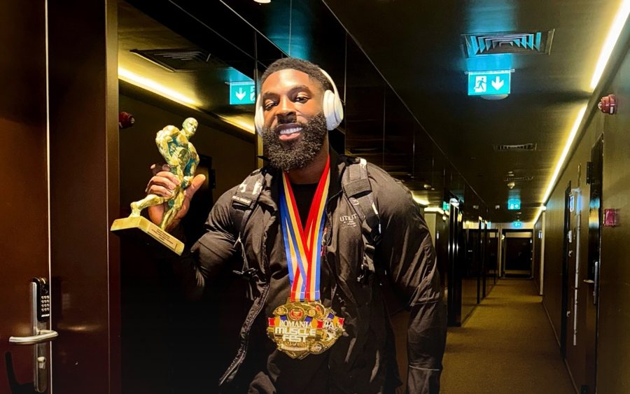 Dwayne Latinwo with his IFBB Pro card and medals